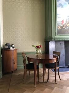 a dining room with a wooden table and chairs at De Carper in Middelburg +12 photos