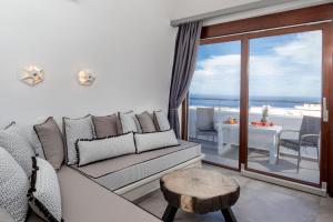 a living room with a couch and a view of the ocean at Irene City Villas in Fira