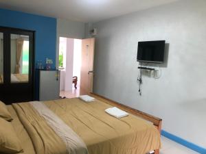 een slaapkamer met een bed en een flatscreen-tv aan de muur bij S Diamond Apartment in Phetchaburi
