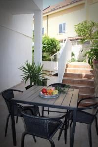 una mesa y sillas con un plato de fruta. en Apartments Giardino, en Hvar
