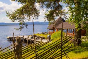 a house on the shore of a lake with a dock at Herranniemi Guesthouse in Vuonislahti