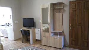 una sala de estar con TV y una habitación con puerta en Apartments I & I, en Beregovo