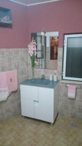 a bathroom with a sink with a vase of flowers on it at Casa Largo da Praça in Alcongosta
