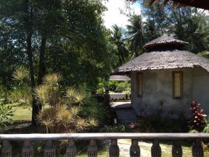 a small hut with a thatched roof in a garden at Malibu Beach Bungalows in Chaloklum