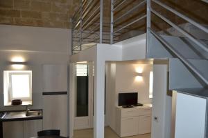 un salon avec un escalier et une télévision dans l'établissement BRG APARTMENTS, à Matera