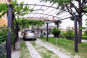 un'auto parcheggiata sotto un pergolato in un cortile di Villa UMA a Izola