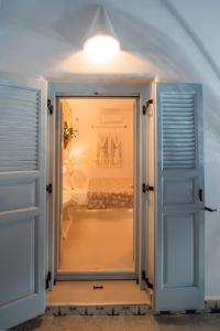 una porta aperta che conduce a una camera con letto di Starlight Luxury Seaside Villa & Suites a Imerovigli