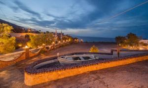 łódź siedząca na plaży w nocy w obiekcie Starlight Luxury Seaside Villa & Suites w Imerovíglion
