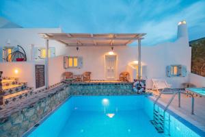 a villa with a swimming pool at night at Starlight Luxury Seaside Villa & Suites in Imerovigli