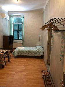een slaapkamer met een bed, een tafel en een raam bij Cavour Guest House in Ventimiglia