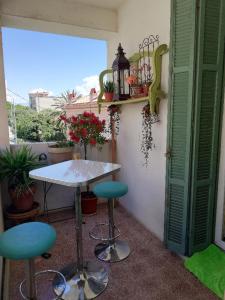 a table and two stools in a room with a window at Villa Cécile in Ajaccio