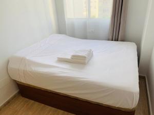 een bed met witte lakens en handdoeken erop bij Apartment in Torrevieja