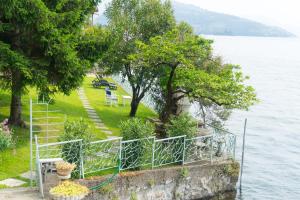 a park next to a body of water with trees at La Casina a Remi in Marone