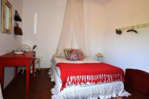 アロウカにあるCasinha à Portaのベッドルーム1室(赤い毛布付きのベッド1台付)