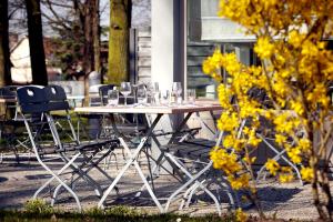 a white table with chairs and glasses on it at Campanile NATURE - Compiegne in Compiègne