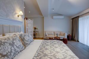 a bedroom with a large bed and a couch at Hotel Passport Tbilisi in Tbilisi City +55 photos