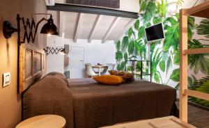 a bedroom with a large bed with plants on the wall at 150 LatoMare in Marina di Carrara