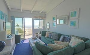 a living room with a green couch and a balcony at Sea Crest in Amagansett