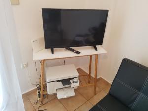 a television sitting on a table with a printer at Filopappou Hill Apartment in Athens