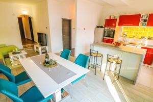 a kitchen and living room with a table and chairs at Apartments Andrea in Baška