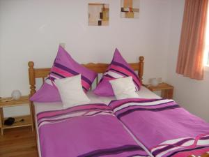 a bed with purple sheets and white pillows at Ferienwohnung Dürbaum in Schleiden