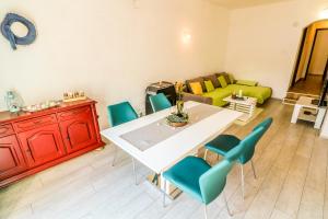 a living room with a white table and blue chairs at Apartments Andrea in Baška