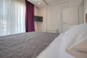 a bedroom with a large bed and a window at Guest House Pržno Bay in Sveti Stefan