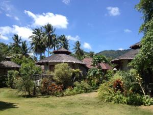 a group of huts with palm trees in the background at Malibu Beach Bungalows in Chaloklum