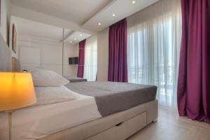 a bedroom with a large bed with purple curtains at Guest House Pržno Bay in Sveti Stefan