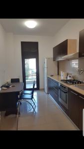 a kitchen with a table and a stove and refrigerator at Apartament Mamaia in Mamaia