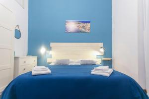 - une chambre bleue avec un lit et des serviettes dans l'établissement mancini house, à Naples