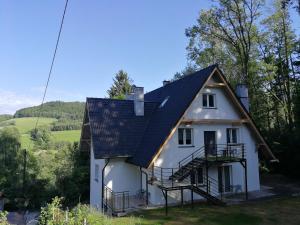 a white house with a black roof at Villa Sudecka in Duszniki Zdrój