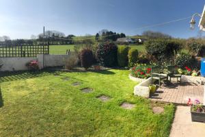 a garden with benches and flowers in a yard at Little Mead. in Tenby