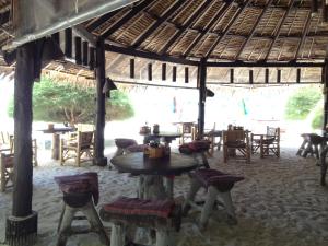 a restaurant with a table and chairs in a pavilion at Malibu Beach Bungalows in Chaloklum