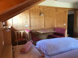 sypialnia z łóżkiem, stołem i krzesłami w obiekcie Chalet Romy AP 3 w mieście Pramauron