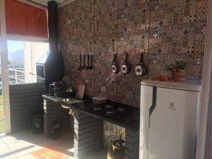 a kitchen with a stove and a refrigerator in a room at Amsterdam Lofts Deluxe in Poços de Caldas