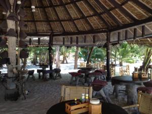 a restaurant on the beach with tables and chairs at Malibu Beach Bungalows in Chaloklum