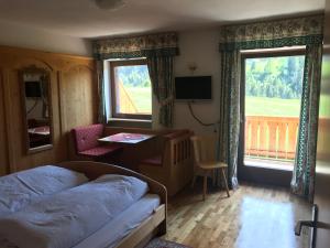a bedroom with a bed and a desk and windows at Chalet Romy Ap2 in Pramauron