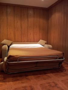 a large bed in a room with wooden walls at Alojamientos Río Cares in León