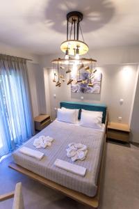 a bedroom with a large bed with two towels on it at Moonline Maisonettes & Apartments in Parga