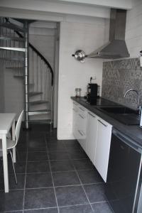 a kitchen with a sink and a table and a staircase at Petit nid à 50m de la plage au coeur de Fouras in Fouras