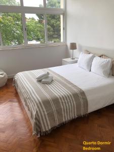 um quarto branco com uma cama grande e 2 janelas em Apartment near the airport em Lisboa