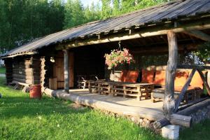 a log cabin with a table and flowers on it at Pedaja Puhketalu in Nulga