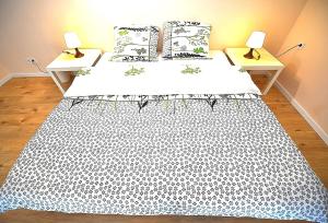 een bed met een zwart-witte sprei en 2 lampen bij White Rose apartment in Boedapest