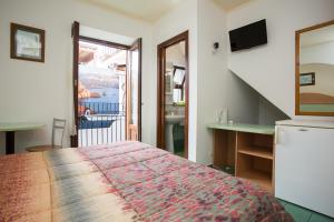 a bedroom with a bed and a bathroom with a balcony at Diana Brown B&B Affittacamere in Lipari