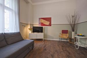 een woonkamer met een bank en een tv bij Wohnung mit 2 Bädern (PB3) in Berlijn