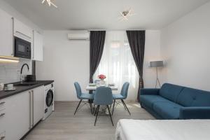 - un salon avec une table et un canapé bleu dans l'établissement Luxury Studios & Rooms Seven, à Split