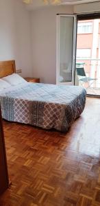 1 cama en un dormitorio con suelo de madera en 3 Bedrooms SOHO Parking Included, en San Sebastián