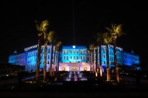 a building with a fountain in front of it at night at Royal Maxim Palace Kempinski Cairo in Cairo