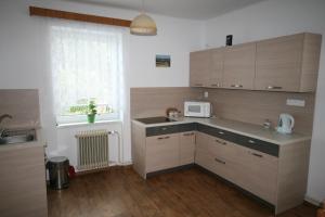 a kitchen with wooden cabinets and a sink and a window at Ubytování v Proseči in Proseč